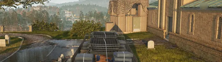 Loaded Ural truck with sandbags and mats beside a stone church, graveyard and a camo-netted tower in WARDOGS
