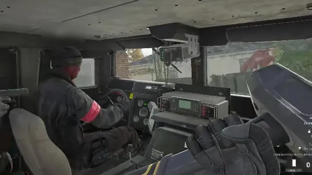 Riding in a military vehicle beside a driver with a red armband and a dash-mounted radio
